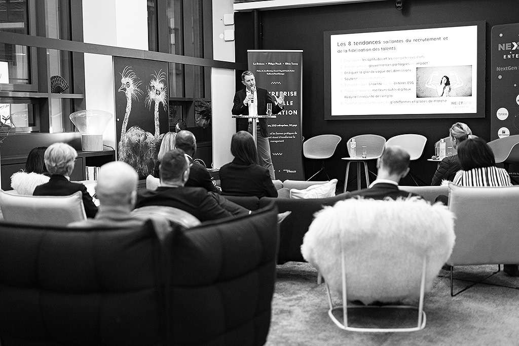A NextGen Club event in March 2022: a speaker presents to a seated audience