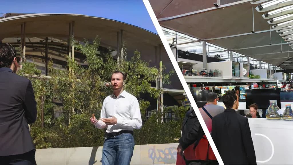 A speaker addresses a group outdoors, under a curved roof